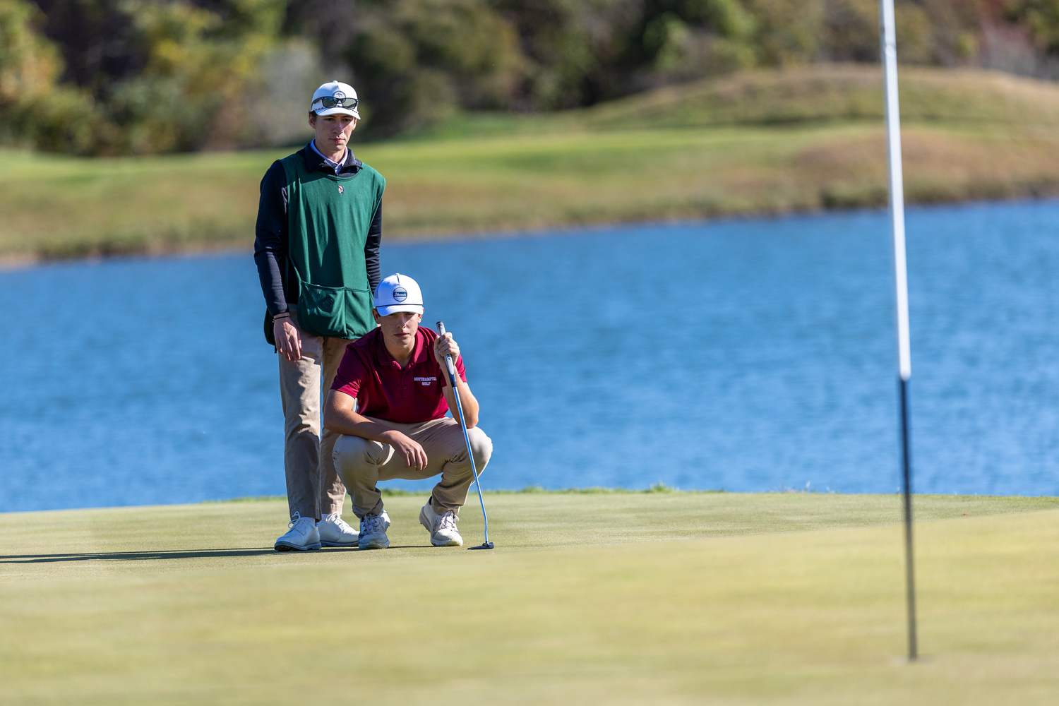 Southampton senior and caddie Jett DeSane helps junior teammate Colin DiLaleo line up a putt.   RON ESPOSITO