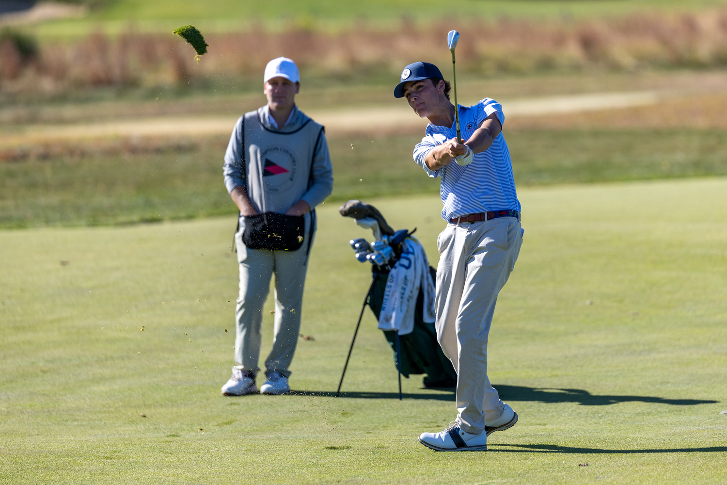 Owen Jessop takes a swing as teammate and caddie Reid Groth looks on.   RON ESPOSITO