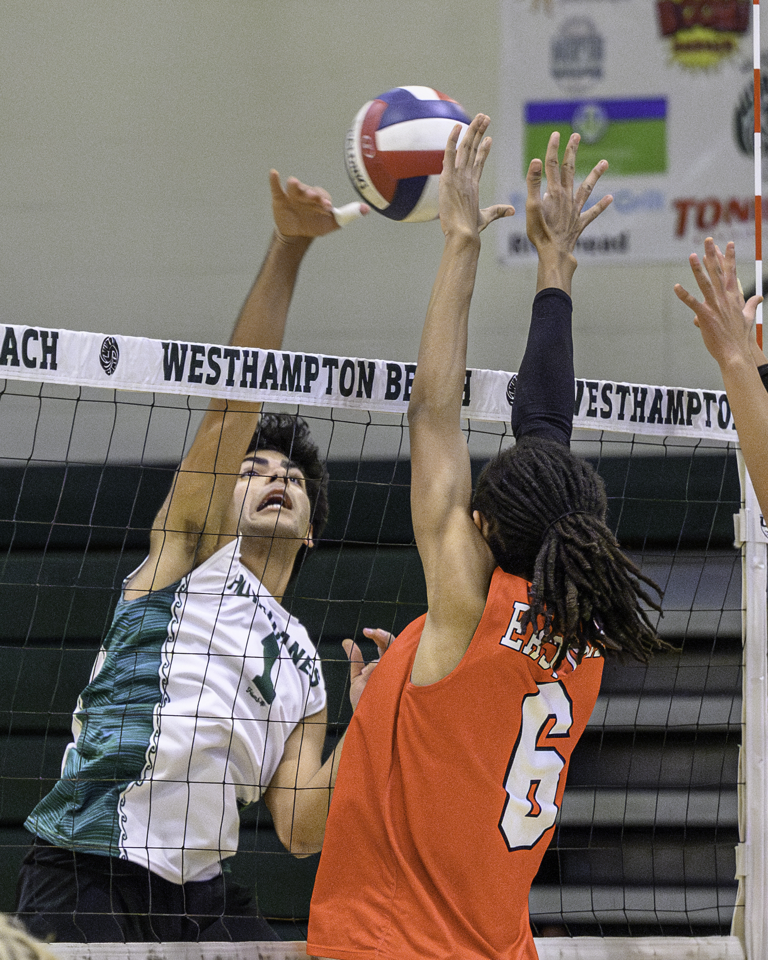 Senior outside hitter Mustafa Gulsen spikes a kill through East Islip blockers. MARIANNE BARNETT