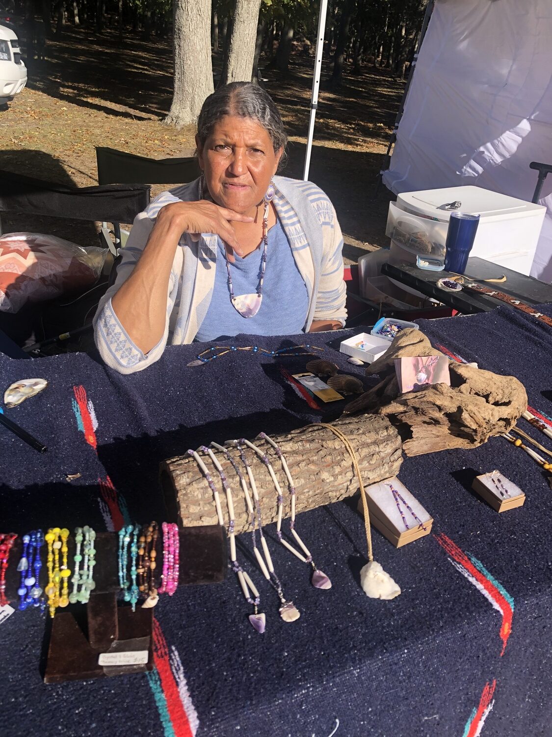 Artisan Josephine Smith at this year's Oyster Festival at the reservation. She uses wampum quahog clam shells whose light purple hue makes for beautiful jewelry. Warmer, more acidic waters are weakening the shells, making them more brittle and harder to work with. JENNY NOBLE