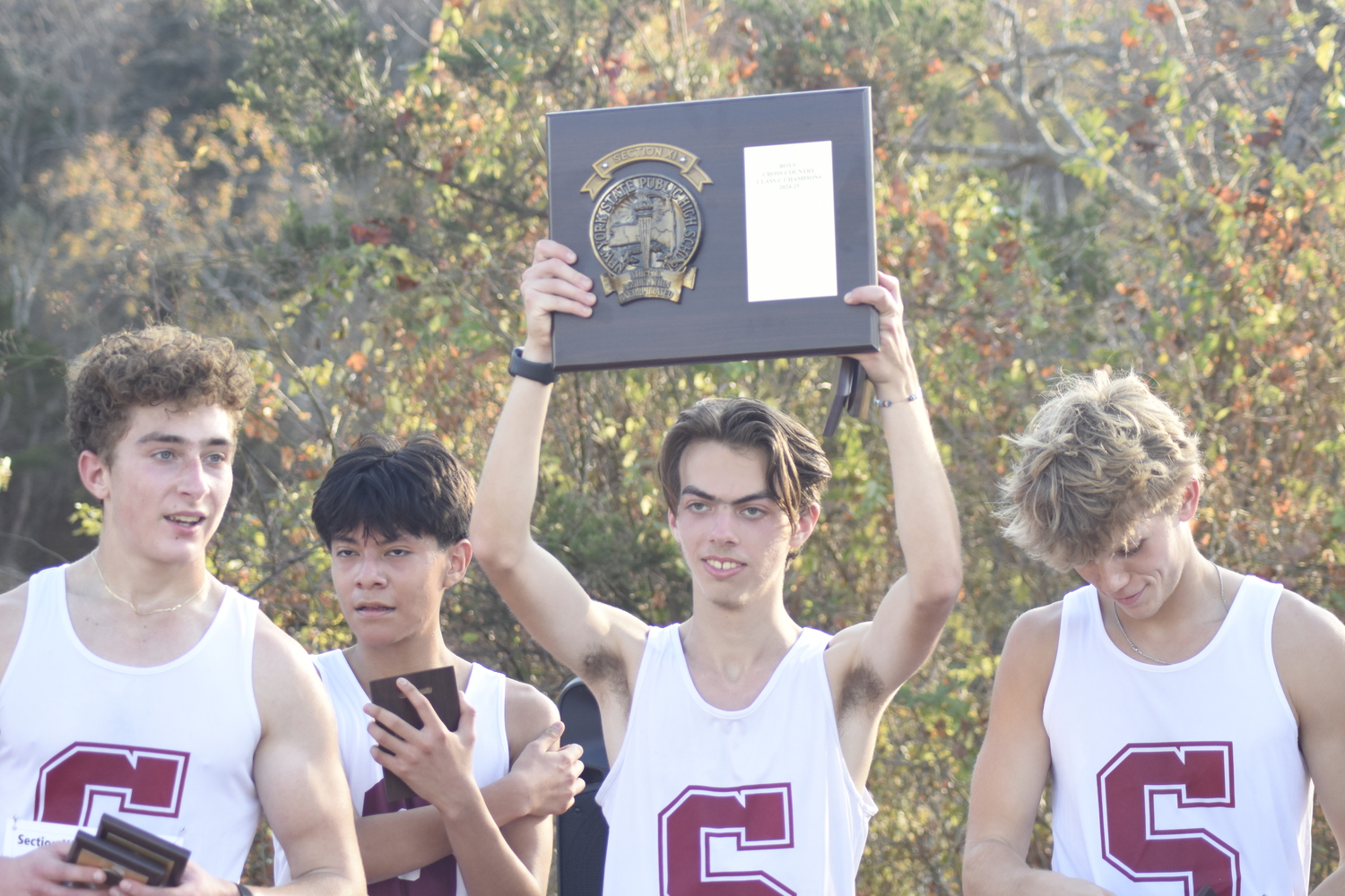 Jake Cook raises the Suffolk County Class C Championship plaque on November 6.  DREW BUDD