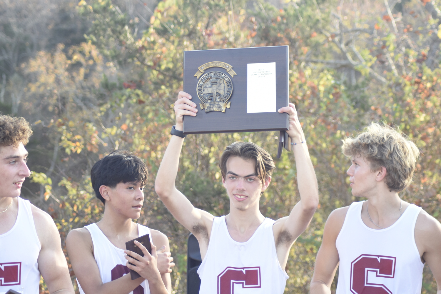 Jake Cook raises the Suffolk County Class C Championship plaque on November 6.  DREW BUDD