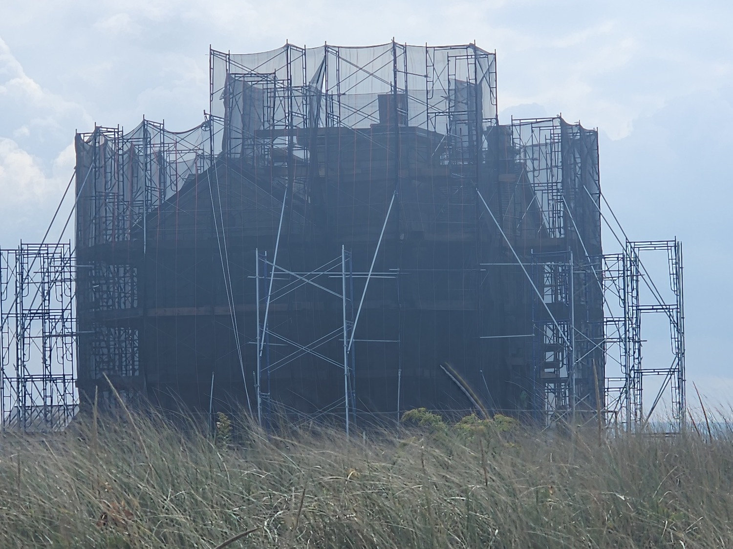 The Cedar Point Lighthouse is surrounded by scaffolding as workers start the task of repointing its stone exterior. COURTESY ANN WELKER