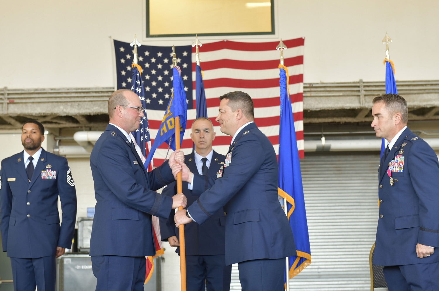 Commander of the New York Air National Guard, Major General Michael Bank, left, passes the flag of the 106th Rescue Wind to Colonel Jeffrey Cannet, signifying the change of command.  DANA SHAW