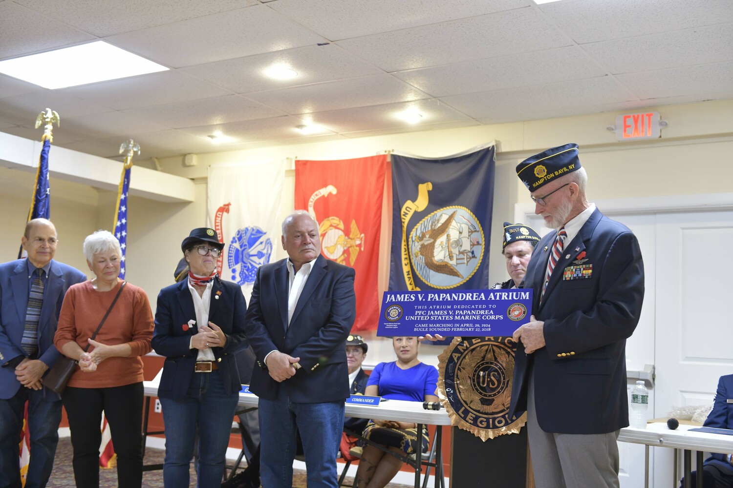 Past Commander Richard Steiber, right presents family members of James Papandrea with a sign dedicating the atrium to him.