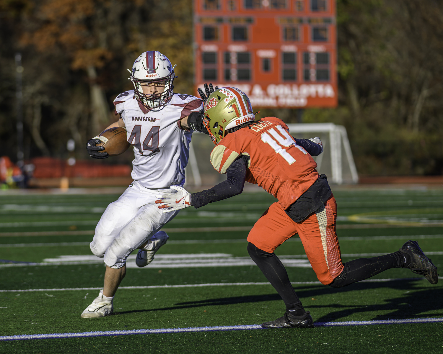 East Hampton sophomore Jackson Ronick stiff arms a Hills West defender.  MARIANNE BARNETT