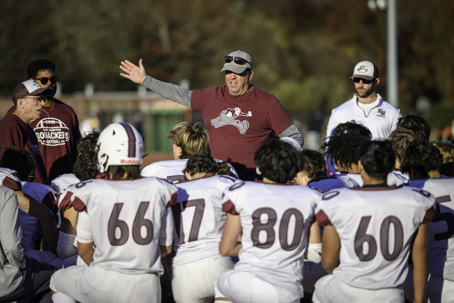 East Hampton head coach Joe McKee congratulates his players on a job well done this season.   MARIANNE BARNETT