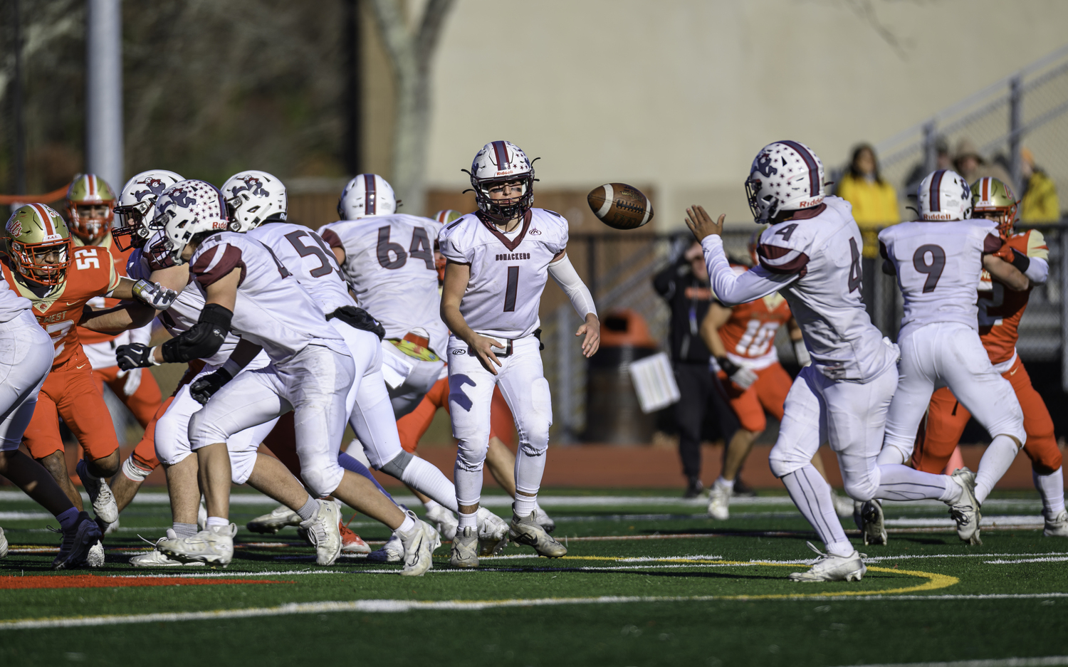 East Hampton junior quarterback Theo Ball tosses the ball to Bridgehampton junior running back Alex Davis.   MARIANNE BARNETT