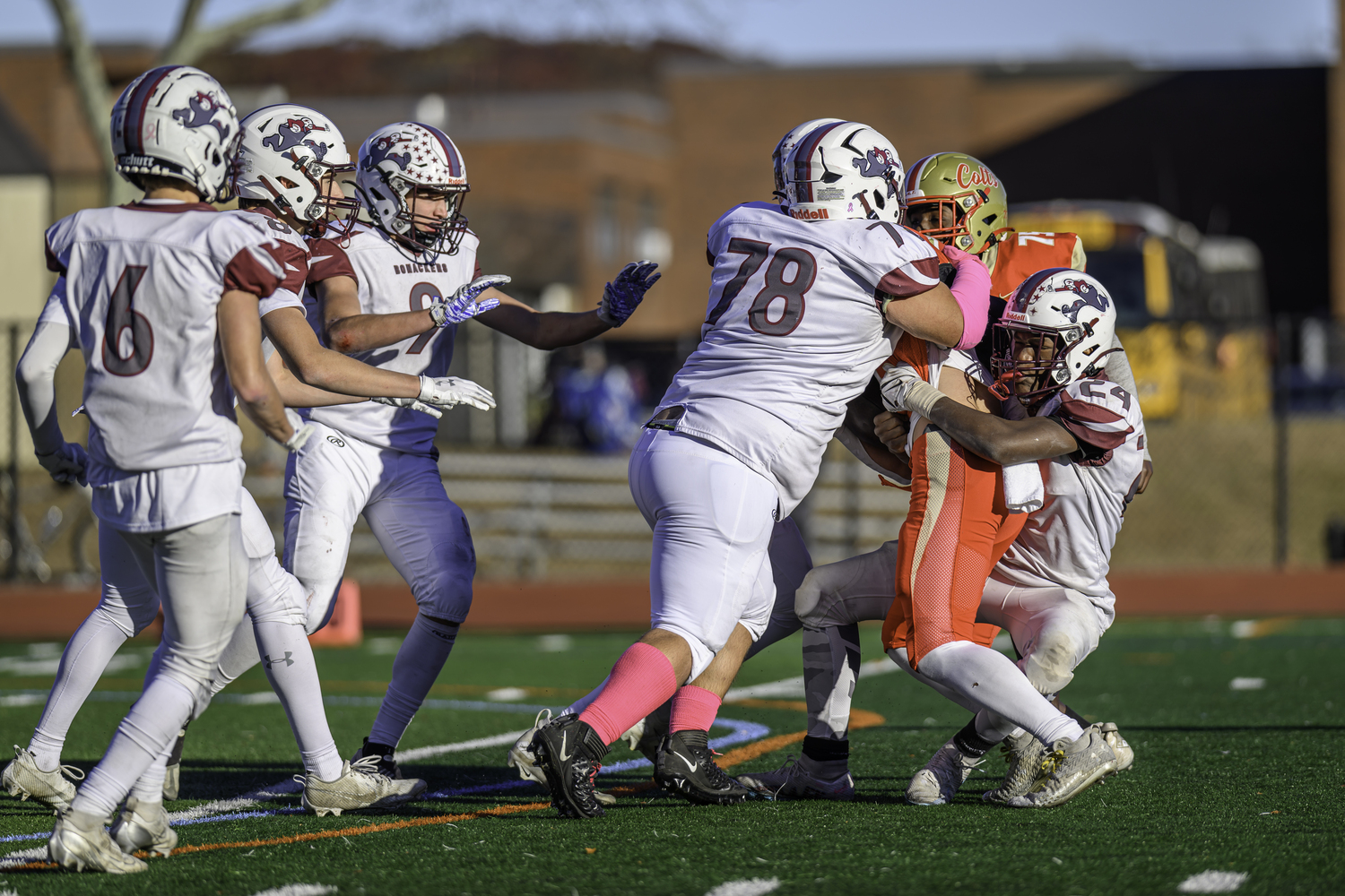 Dylan Ward (78) and Dame Moore (24) take down a Hills West player.  MARIANNE BARNETT