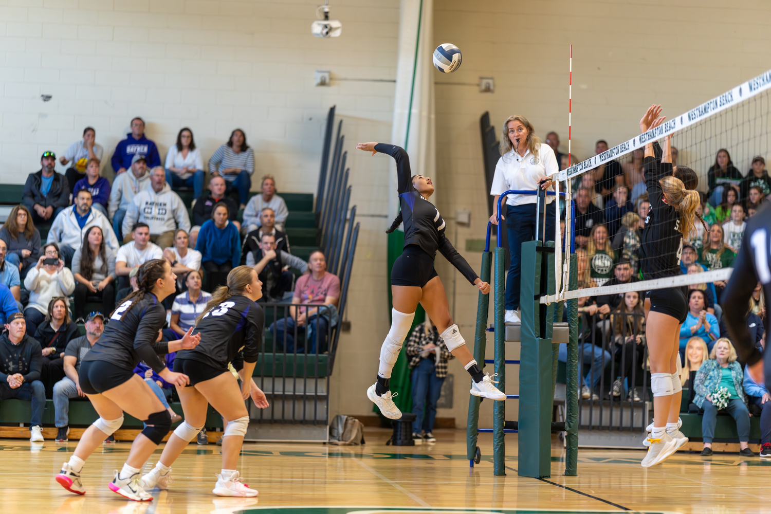 Hampton Bays senior middle blocker Asha Pensa-Johnson jumps to slam down a kill. RON ESPOSITO