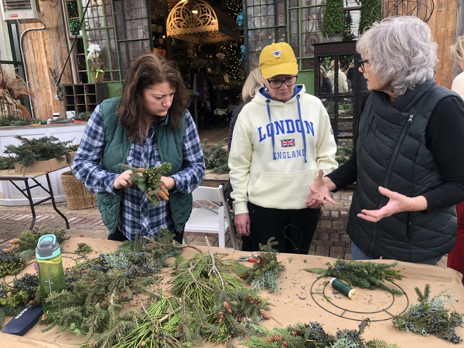 Sharon Bendzlowicz, left, and June Hamilton work on their wreaths with guidance from Denise Kelly. CAILIN RILEY