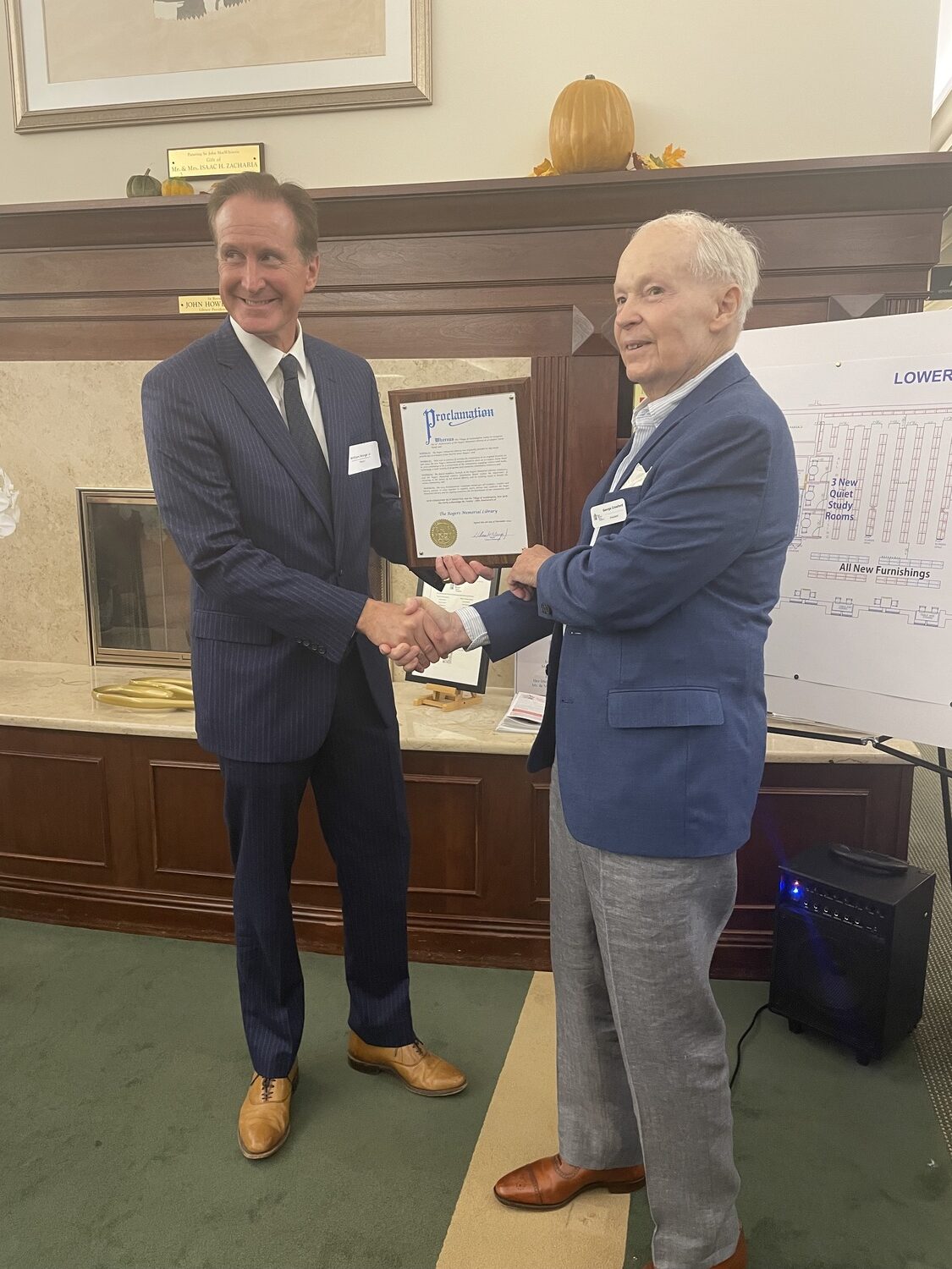 Southampton Village Mayor Bill Manger, left, presents library foundation board president George Crawford with a proclamation recognizing the library for its service to the community. CAILIN RILEY