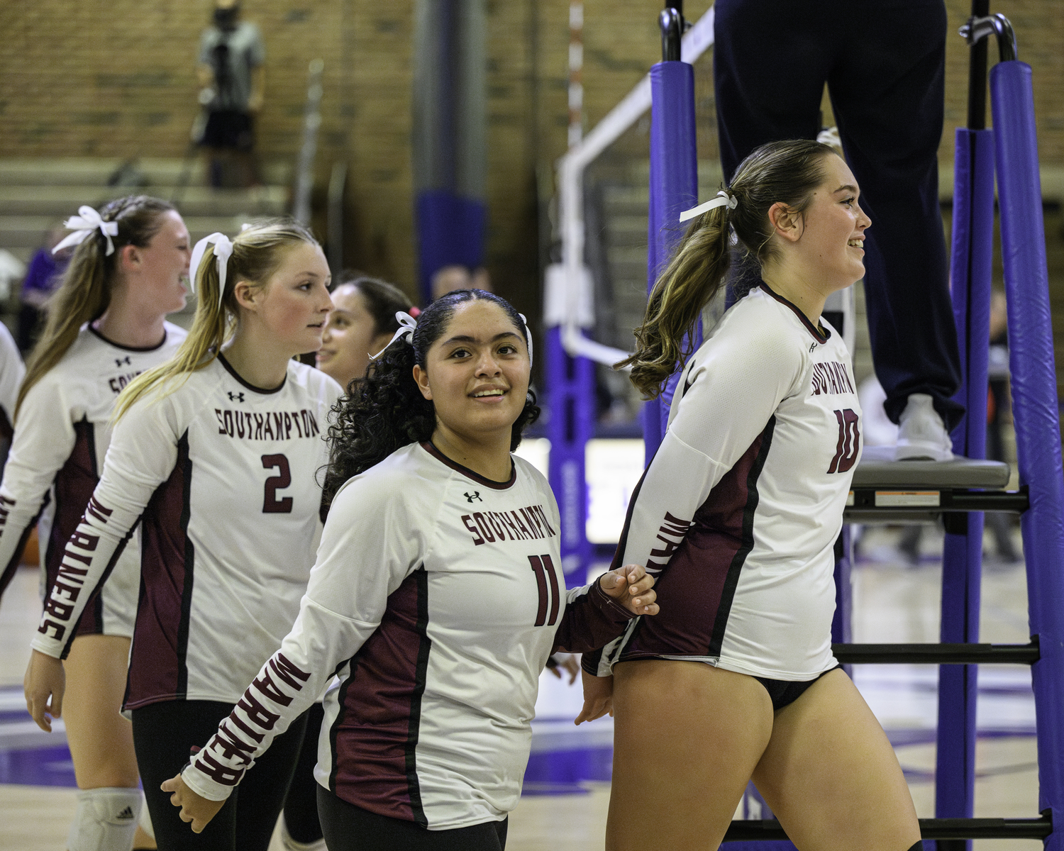 Lucia Obregon (11), Avery Greene (10) and the rest of the Mariners are all smiles after winning the second set and tying the match, 1-1.   MARIANNE BARNETT