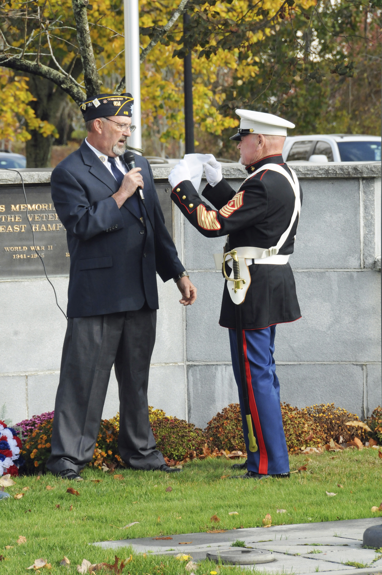 The VFW's Brian Carabine assists American Legion Commander Jeff Kiger during Veterans Day services at Hook Mill in east Hampton on Monday.  RICHARD LEWIN