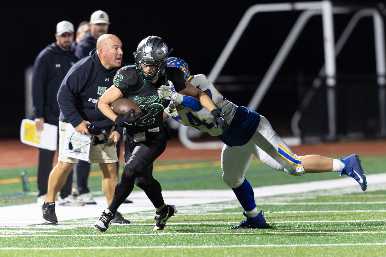 Westhampton Beach senior Brody Schaffer tries to break the tackle of Comsewogue's Arthur Gartland.  RON ESPOSITO