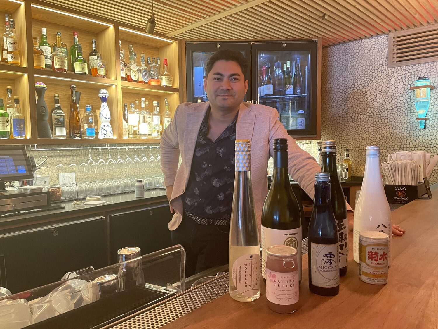 Jesse Matsuoka at Sen's bar with the sakes he discussed at the “Sips of Summer” event hosted by the Express News Group on June 5. GAVIN MENU