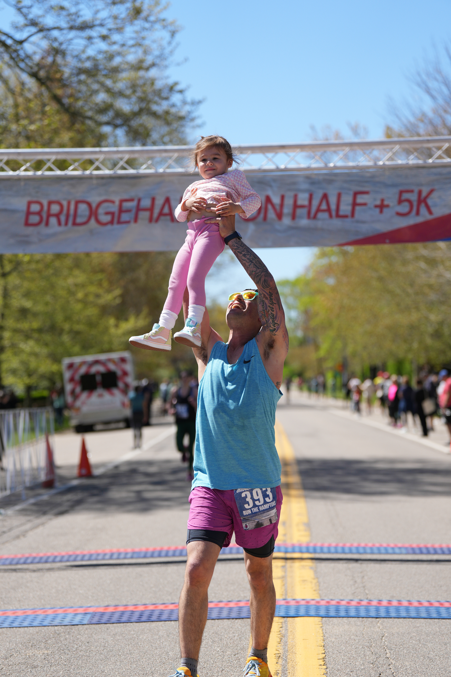 East Hampton resident Anthony Daunt hoists up his daughter after completing a half marathon in Bridgehampton. COURTESY ANTHONY DAUNT