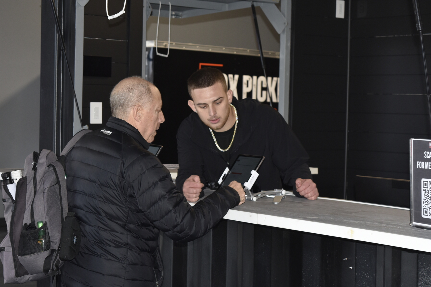 John Berry helps out a customer at the front desk.   DREW BUDD