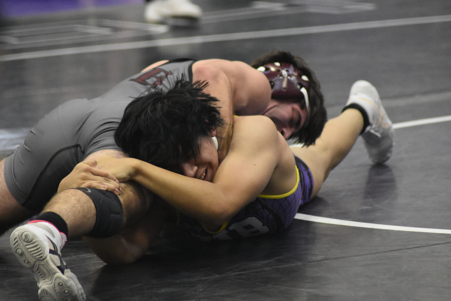 Hampton Bays senior Raul Lopez Ramirez holds on to Justin Prince's leg.  DREW BUDD