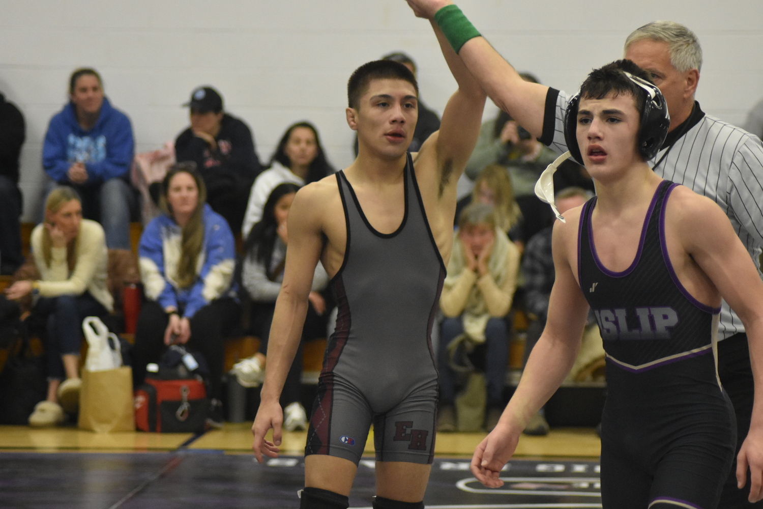 East Hampton senior Juan Roque gets his arm raised after defeated Islip's Matthew Peterson, 12-9, in a sudden victory overtime match.  DREW BUDD