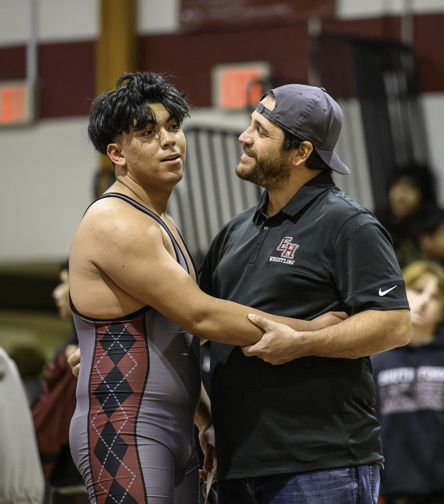 East Hampton junior Juan Espinoza is congratulated by assistant coach Cory Strain.  MARIANNE BARNETT