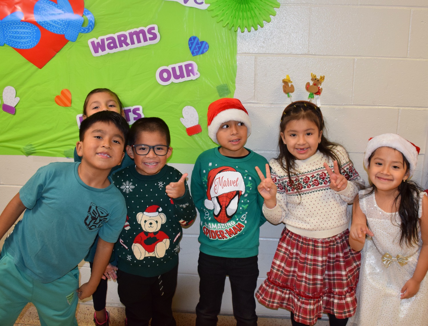 Hampton Bays Elementary School first grade students celebrated the holiday season with their annual “Holidays Around the World,” a festive annual production staged for family and friends. Dressed in colorful holiday outfits, each first grade class stood to recite facts and poems about the various holidays they had studied in class. They also entertained the audience by singing holiday songs. COURTESY HAMPTON BAYS SCHOOL DISTRICT