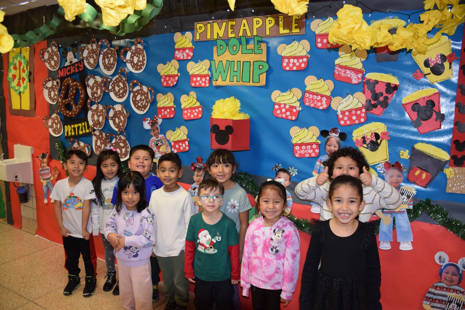 The kindergarten hallway at Hampton Bays Elementary School has been transformed into a holiday wonderland with a theme of Downtown Disney. Teachers and their students worked to bring the vision to life over the past several weeks. Each class created elaborate displays outside their classroom that depict shops from Downtown Disney. There is a Starbucks, Mini Mouse bake shop, Pineapple Dole Whip shop, art and clock stores among others. Students dressed in their holiday best on December 11 to celebrate the completion of the hallway. COURTESY HAMPTON BAYS SCHOOL DISTRICT