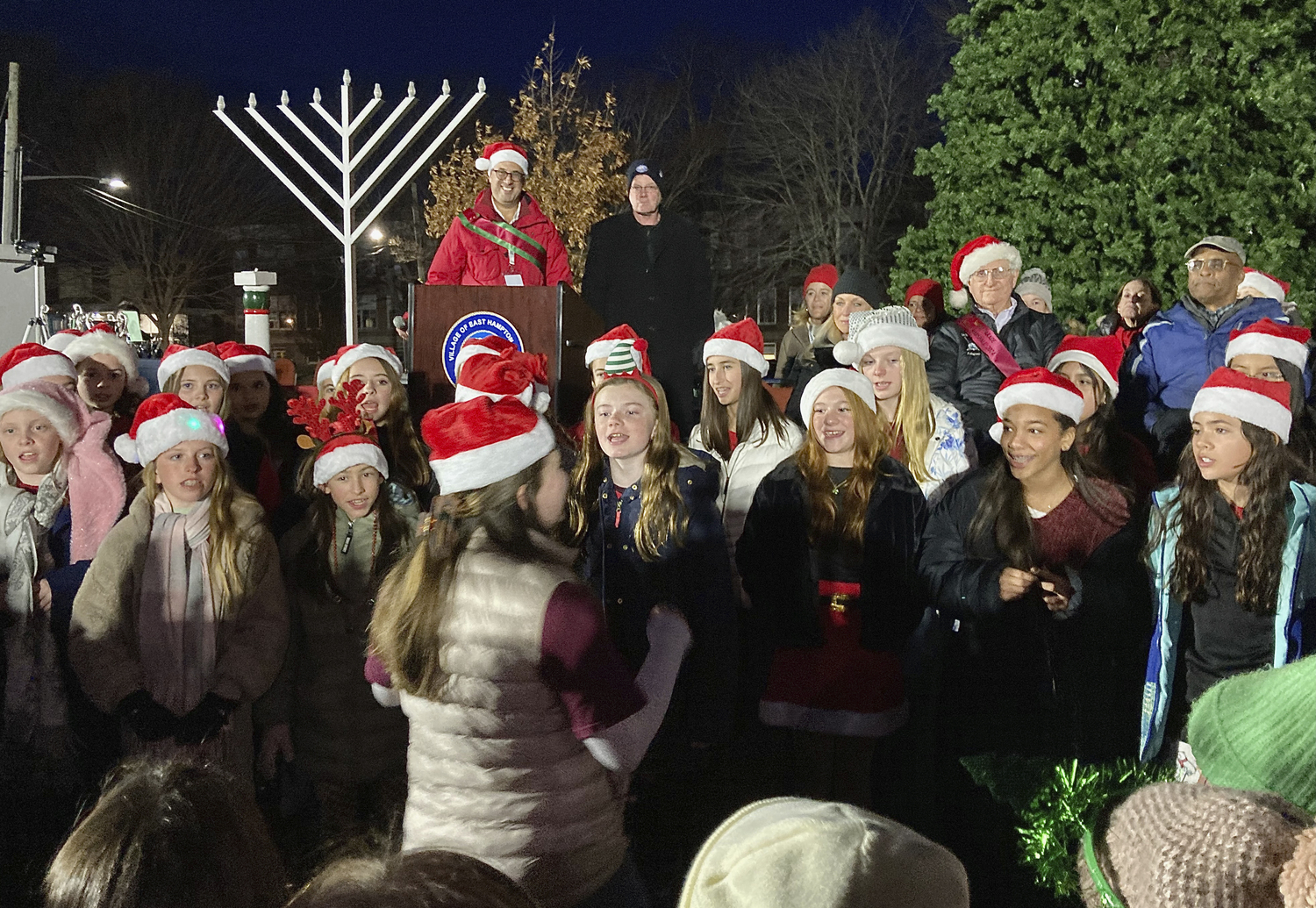 The East Hampton Middle School Bonettes sing carols at the tree lighting in Herrick Park on Saturday evening.  KYRIL BROMLEY