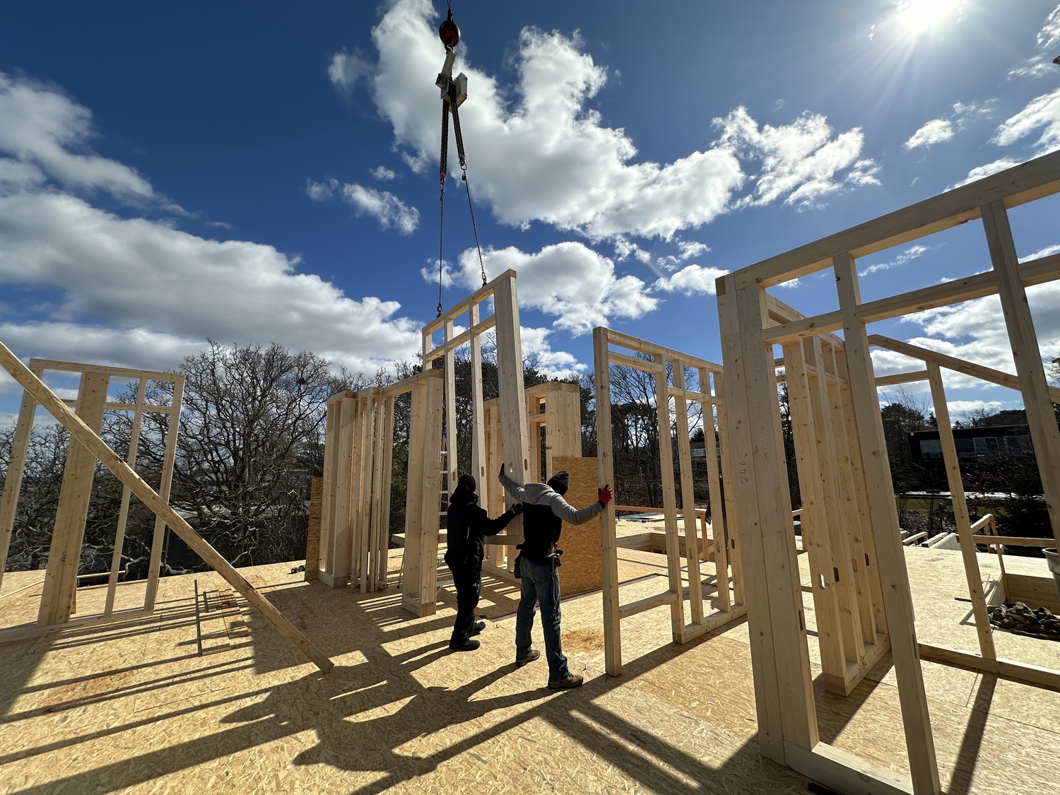 March 7 - Factory Built
BuildLabs takes home construction to the ‘next level’
A crane slowly lowers a package of six sections of 10-foot-tall walls onto the second story of a house being assembled in Hampton Bays fronting Great Peconic Bay. Two workers free one wall section from the package and help the crane guide it precisely into place. A code printed on the wall tells them where it belongs, and bolts preinstalled in the floor allow them to secure it in seconds before moving on to the next wall. The walls, floor and roof were all manufactured in a factory in Germany in three weeks, before being shipped to New York and assembled on-site by a crew of four in just two weeks. Punit Chugh, the founder and operations director of BuildLabs in Bridgehampton, says he believes this method is the future of construction.  BRENDAN J. O'REILLY