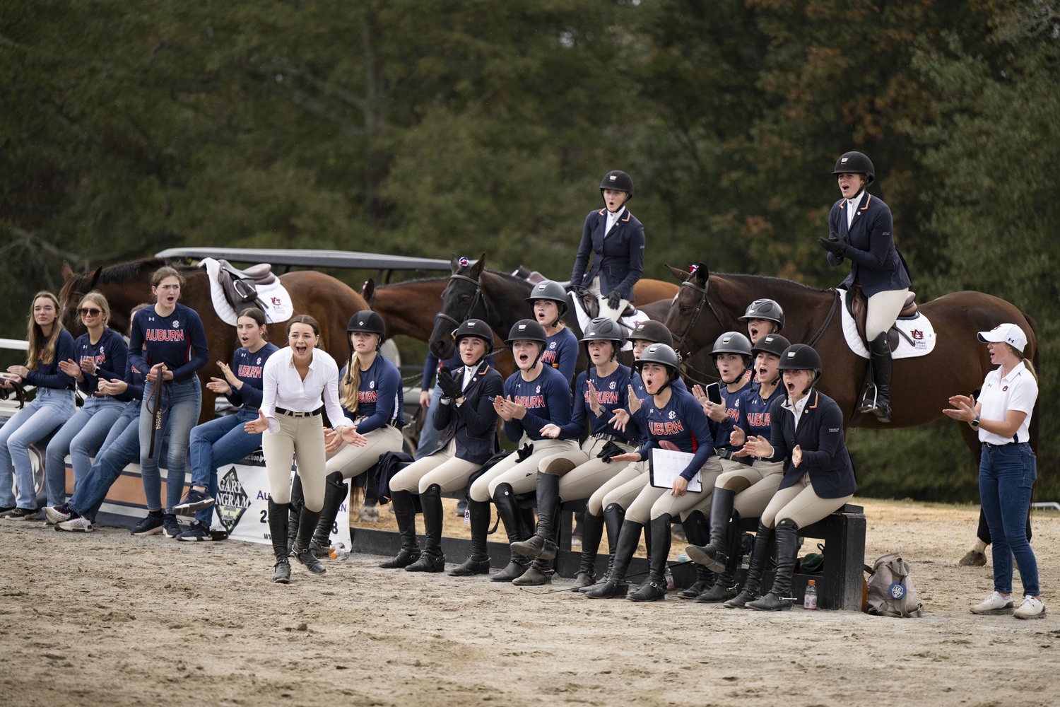 Sadie Berkhout (far right, seated on fence) said she loves being part of the equestrian team, where cheering teammates on loudly is encouraged, as opposed to the traditional horse show environment. COURTESY AUBURN ATHLETICS