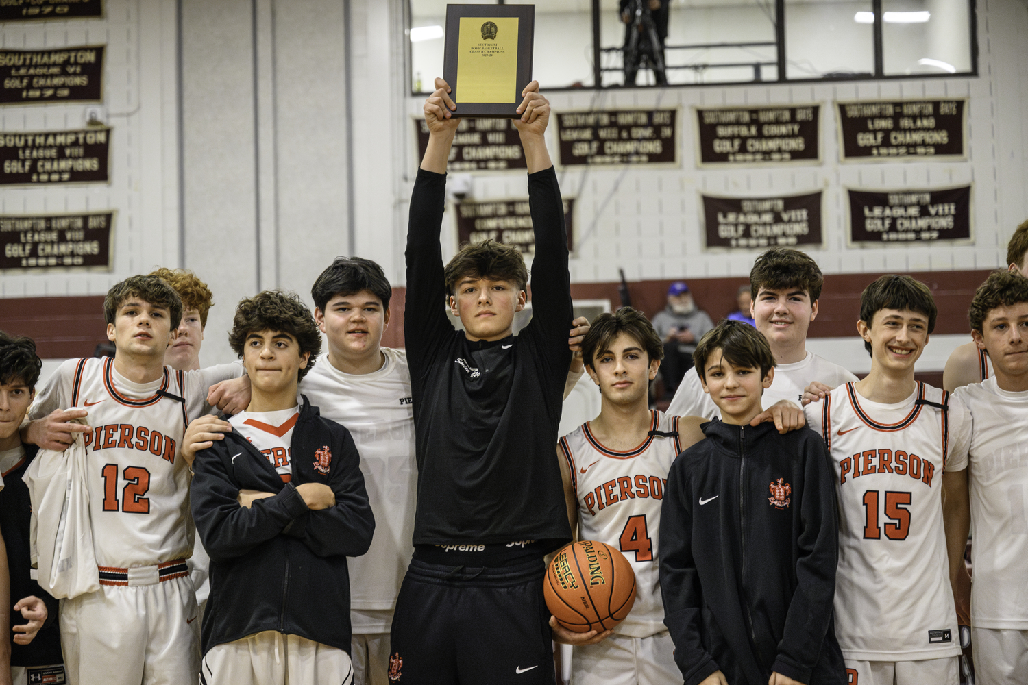 March 7 - Aven Smith hoists the Suffolk County Class B Championship on February 29, the Whalers' third consecutive county title.   MARIANNE BARNETT