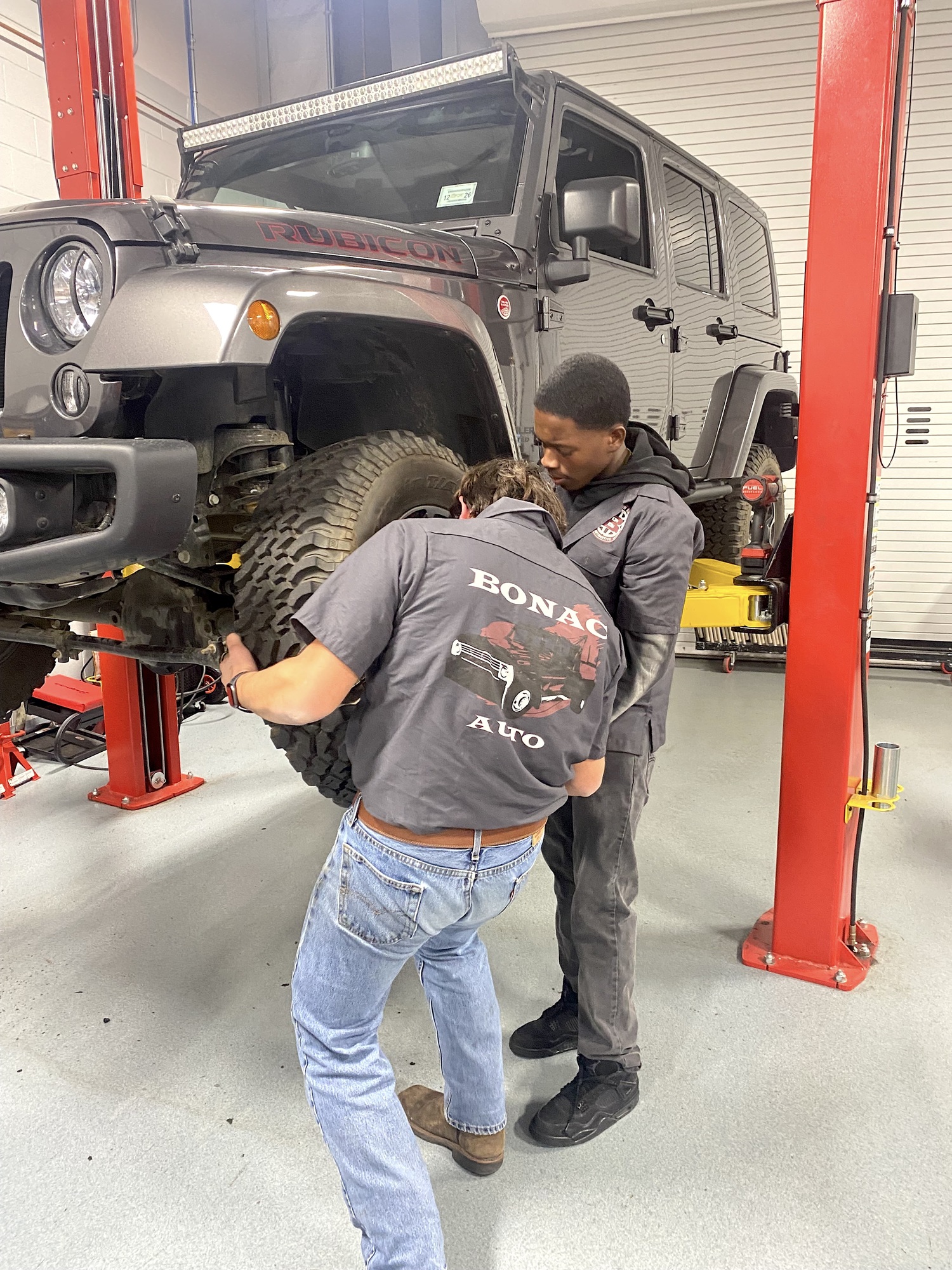 East Hampton seniors John Dunning and Josh Williams, both second-year students in the district's new automotive program, balance the tires on a Jeep Wrangler Rubicon during the December 10 board of education meeting held in the shop. EAST HAMPTON SCHOOL DISTRICT