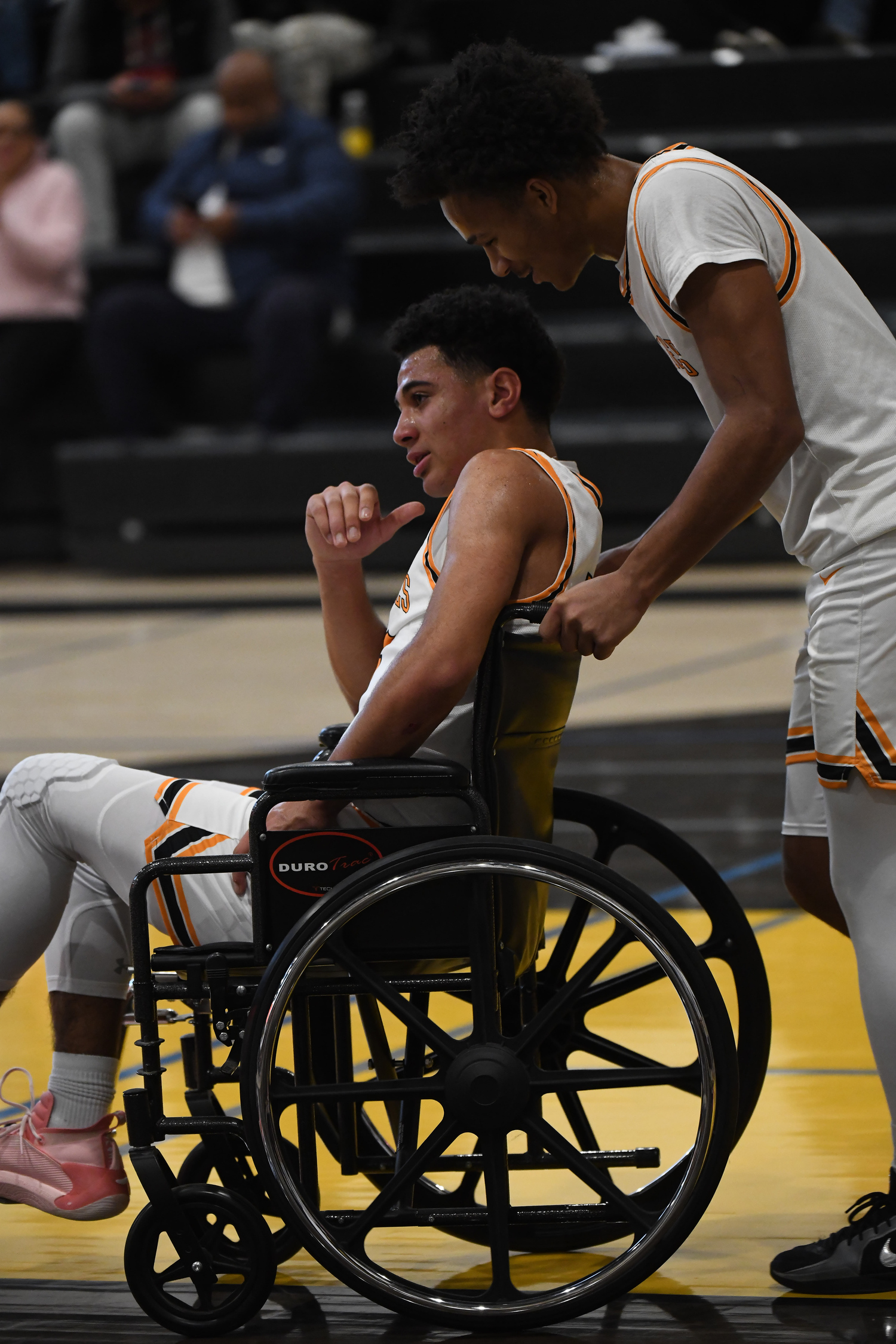 Jai Feaster helps Xavier Johnson off the court after he suffered what is thought to be a hip injury in Saturday afternoon's game.   DOUG KUNTZ