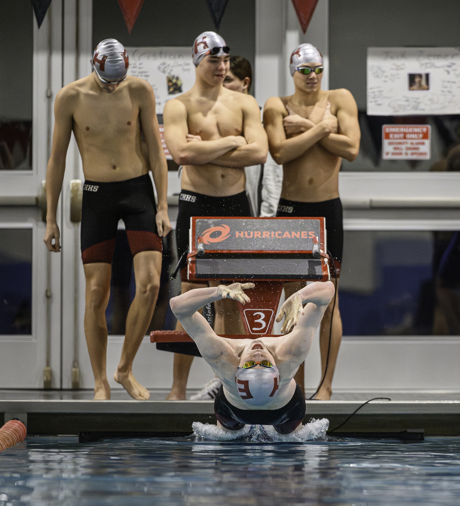 Pierson sophomore Ben Kriegsman dives into the pool as Pierson sophomore Nick Chavez, junior Dylan Knapik and East Hampton junior Liam Knight wait their turn in the 200-yard medley relay that kicked off the final regular-season meet of the season January 16. MARIANNE BARNETT