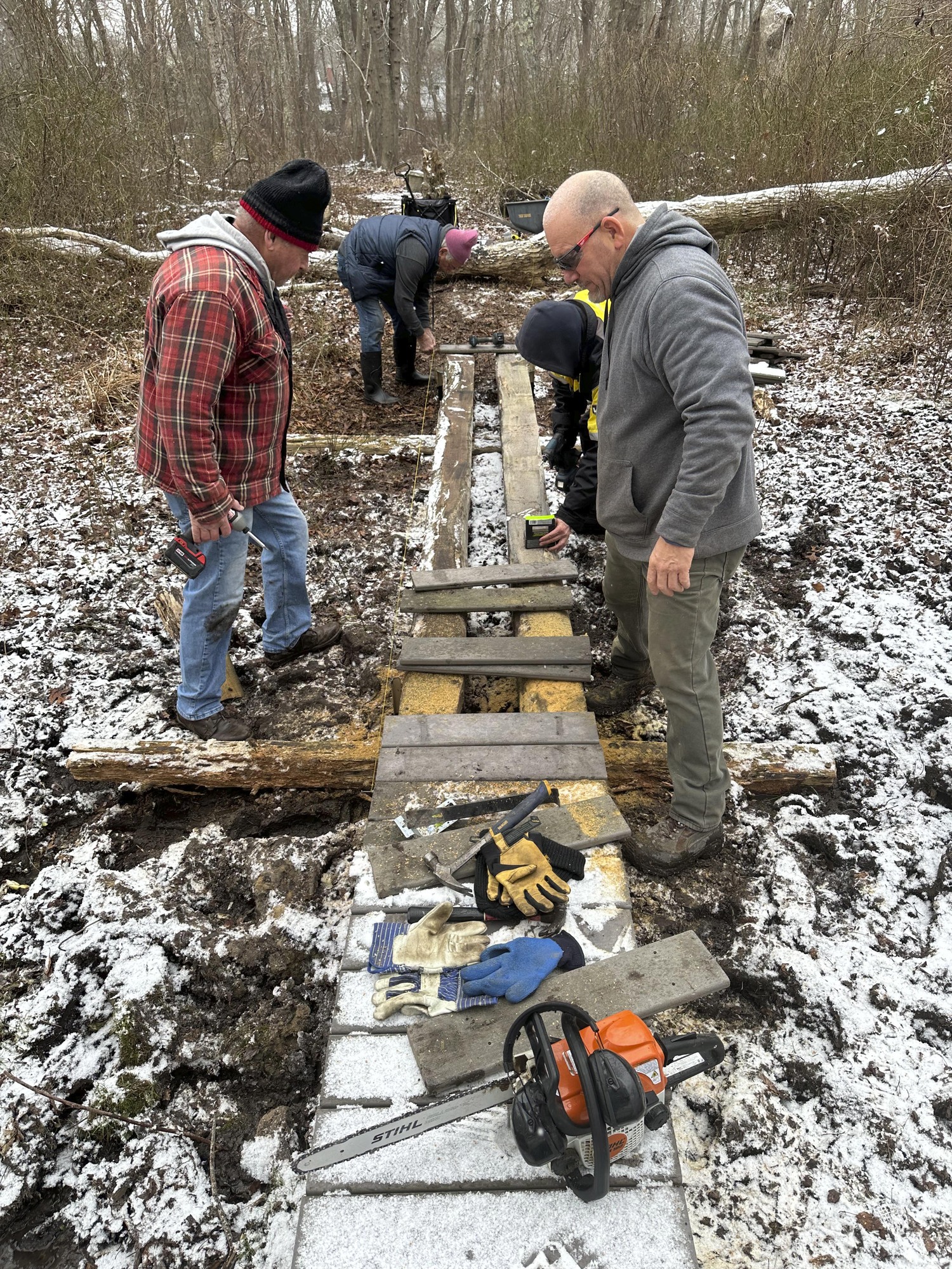 The Brothers of Old Town Masonic Lodge #908 work on  a bridge across the Paumanok Path in North Sea on January 4. The project was completed on   Saturday.    COURTESY TIM CORWIN