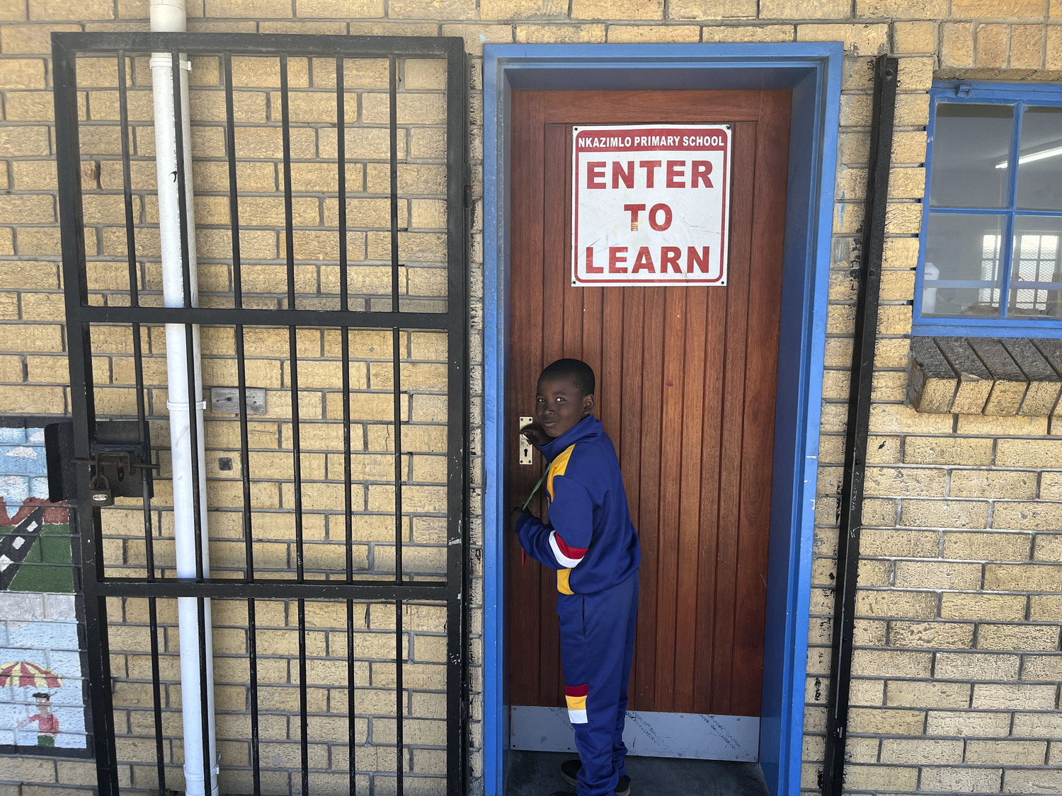 A student about to enter a school in Cape Town, South Africa.  COURTESY ANTHONY ALLISON