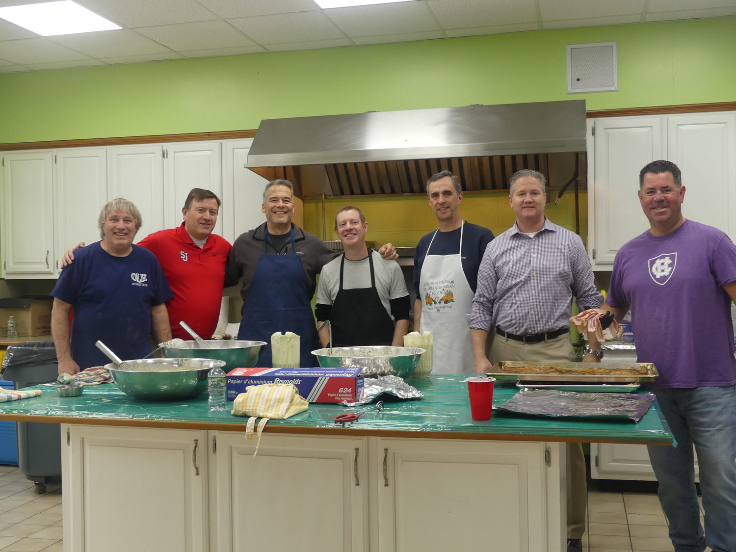 Fathers of Our Lady of the Hamptons School students, from left, Rocky Ambrose, John Saville, Gaylord Hoffert, Francis Molignano, Peter McGreevy, John Brady, Brendan Kenny, cooked up the fare at the school's recent pancake breakfast. Prep 7 student Colleen Lynch was a server.  COURTESY OUR LADY OF THE HAMPTONS SCHOOL