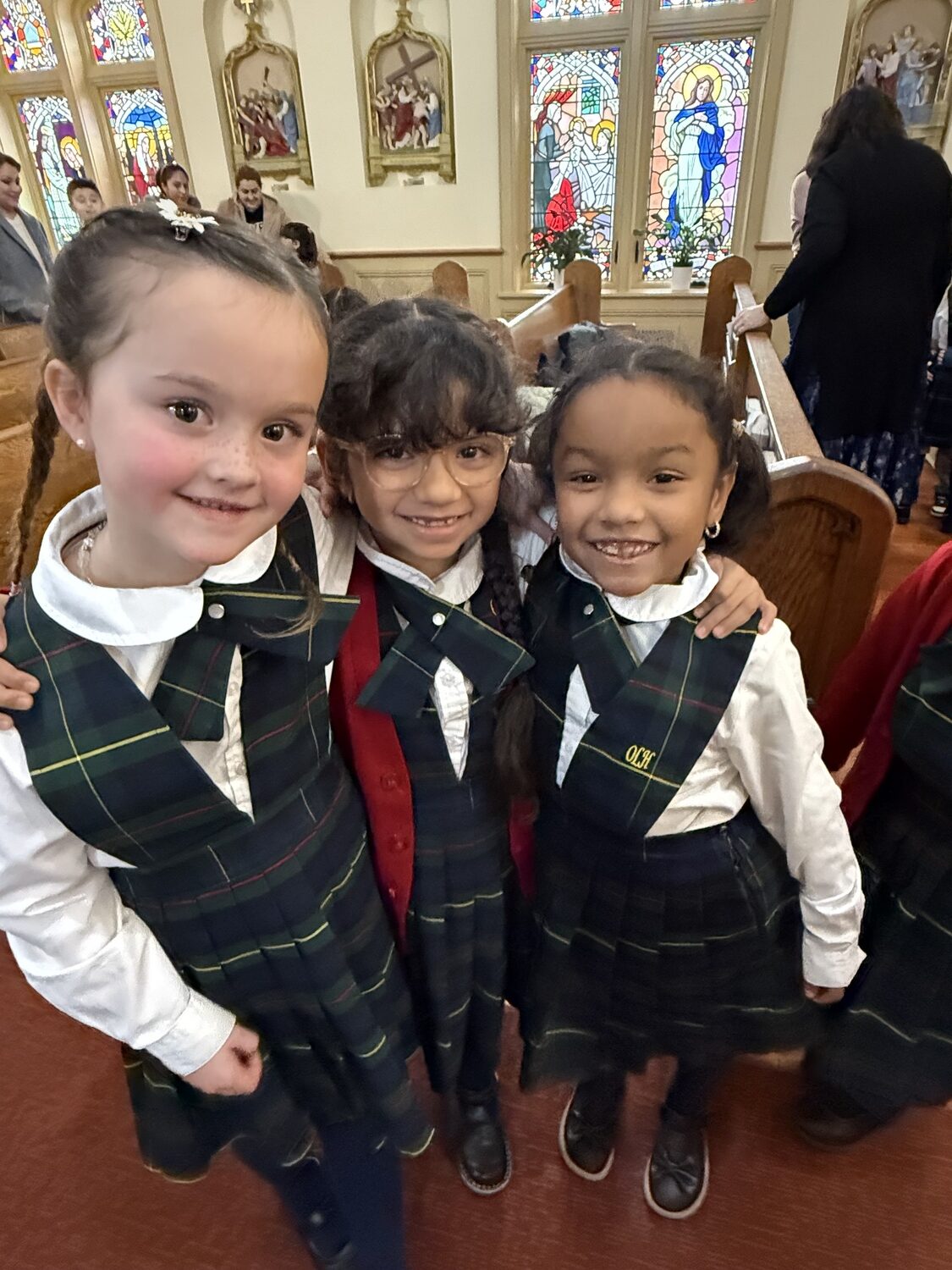 Our Lady of the Hamptons first-graders, from left, Macier Phair, Emily Castaneda and Arianna Quintanilla are all smiles during a recent school day. COURTESY OUR LADY OF THE HAMPTONS