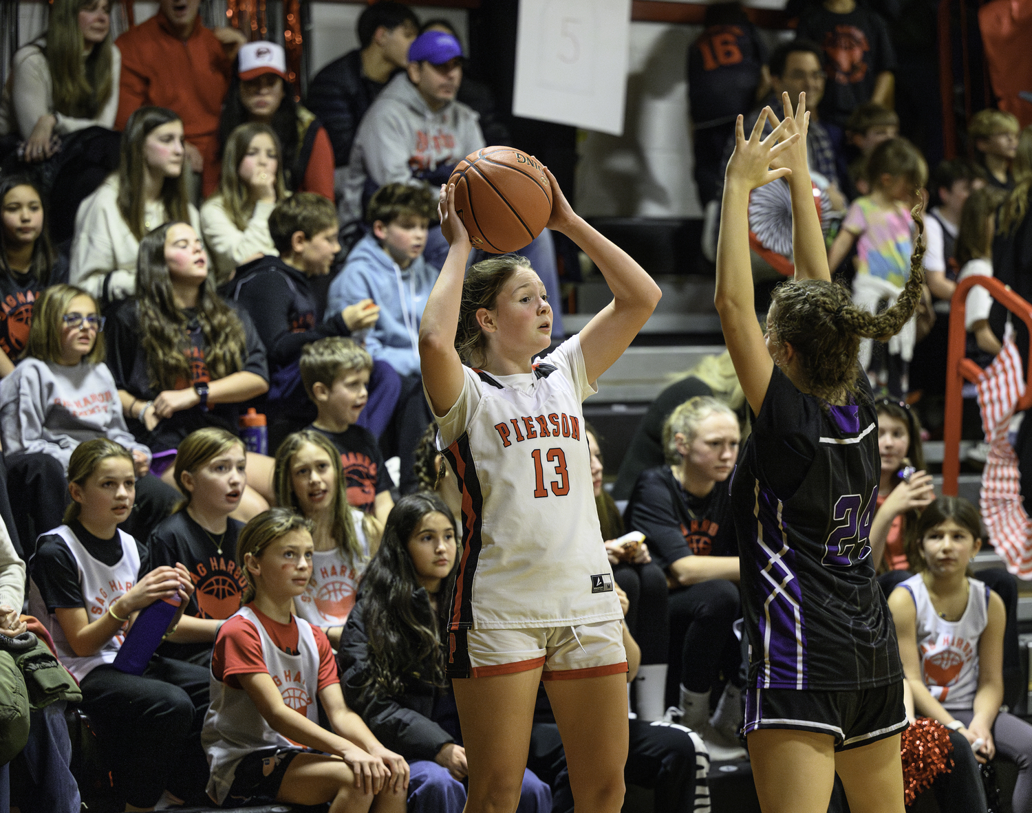 Pierson senior Cali Wilson looks for an open teammate to throw an inbounds pass to while Sag Harbor youth players look on intently on Spirit Night.   MARIANNE BARNETT