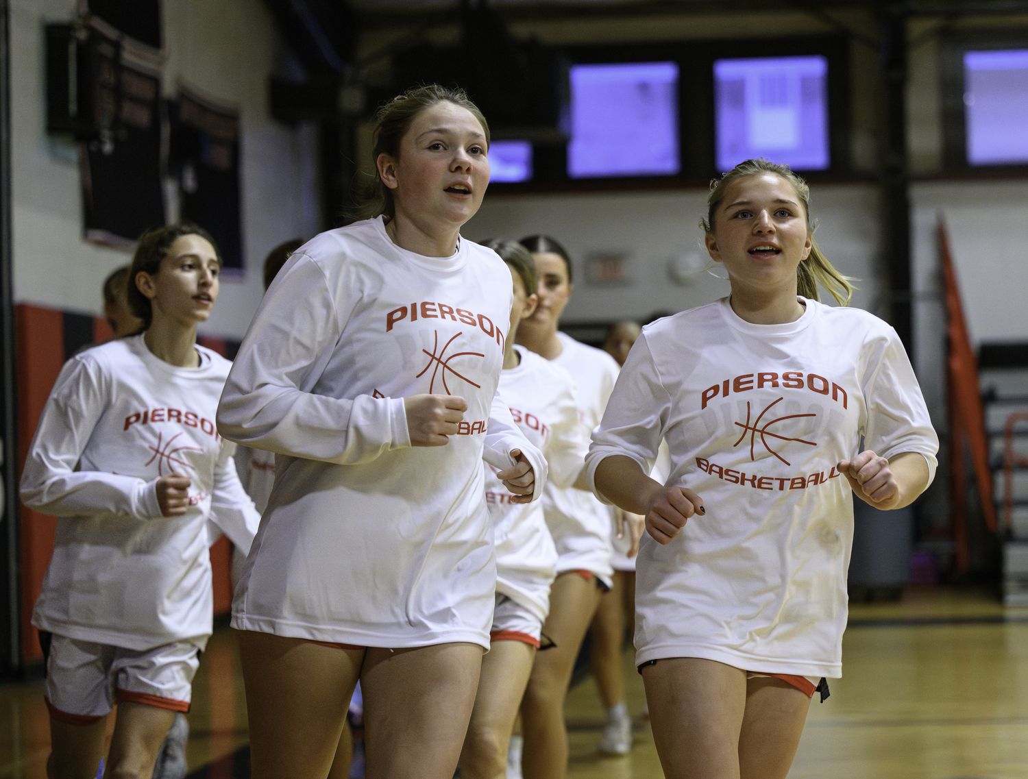 Cali Wilson, left, and Abby Perello lead the warm-up job prior to Friday night's game.   MARIANNE BARNETT