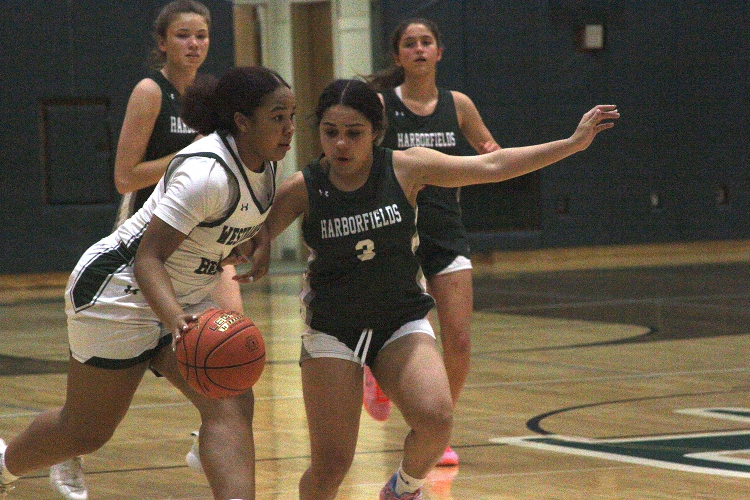 Junior point guard Sandra Clarke drives around Harborfields' Paige Quigley. DESIRÉE KEEGAN