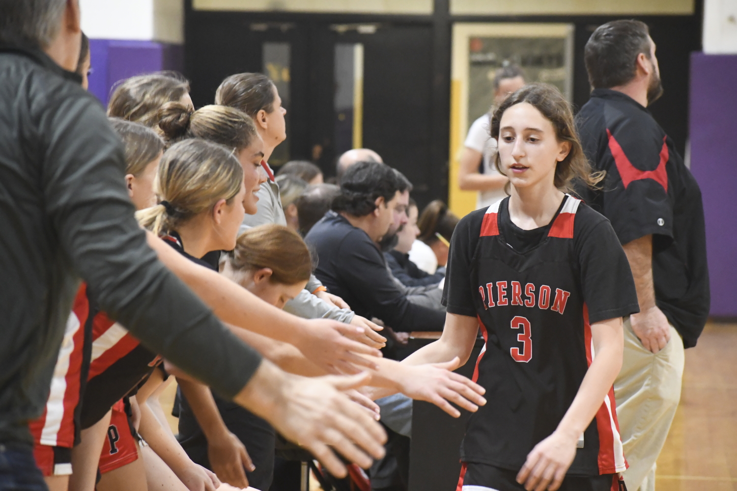 Molly Wolfson gets greeted by teammates and coaches after coming out late in the game.  DREW BUDD