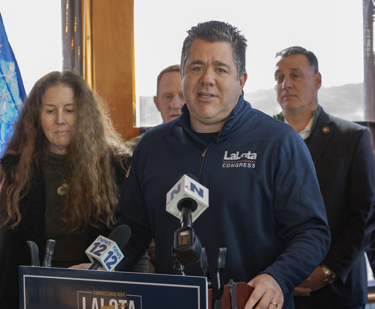 U.S. Representative Nick LaLota speaks to the media about the dredging of the Montauk inlet at Inlet Seafood restaurant on East Lake Drive while protesters walked outside the property line.  DOUG KUNTZ