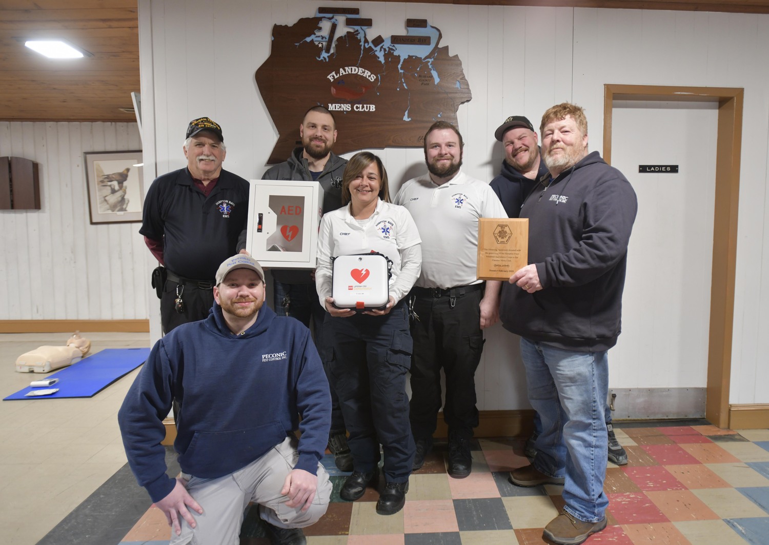 The Hampton Bays Volunteer Ambulance donated an AED (automated external defibrillator) to the Flanders Men's Club on February 19. Left to right are, Jesse Reynolds, Dave Smith, Alek Kozuchowski, First Assistant Chief, Chance Karr, Chief, Robert Scott, Second Assistant Chief, Tommy Griffin and Joe Roth, President, Flanders Men's Club.  DANA SHAW