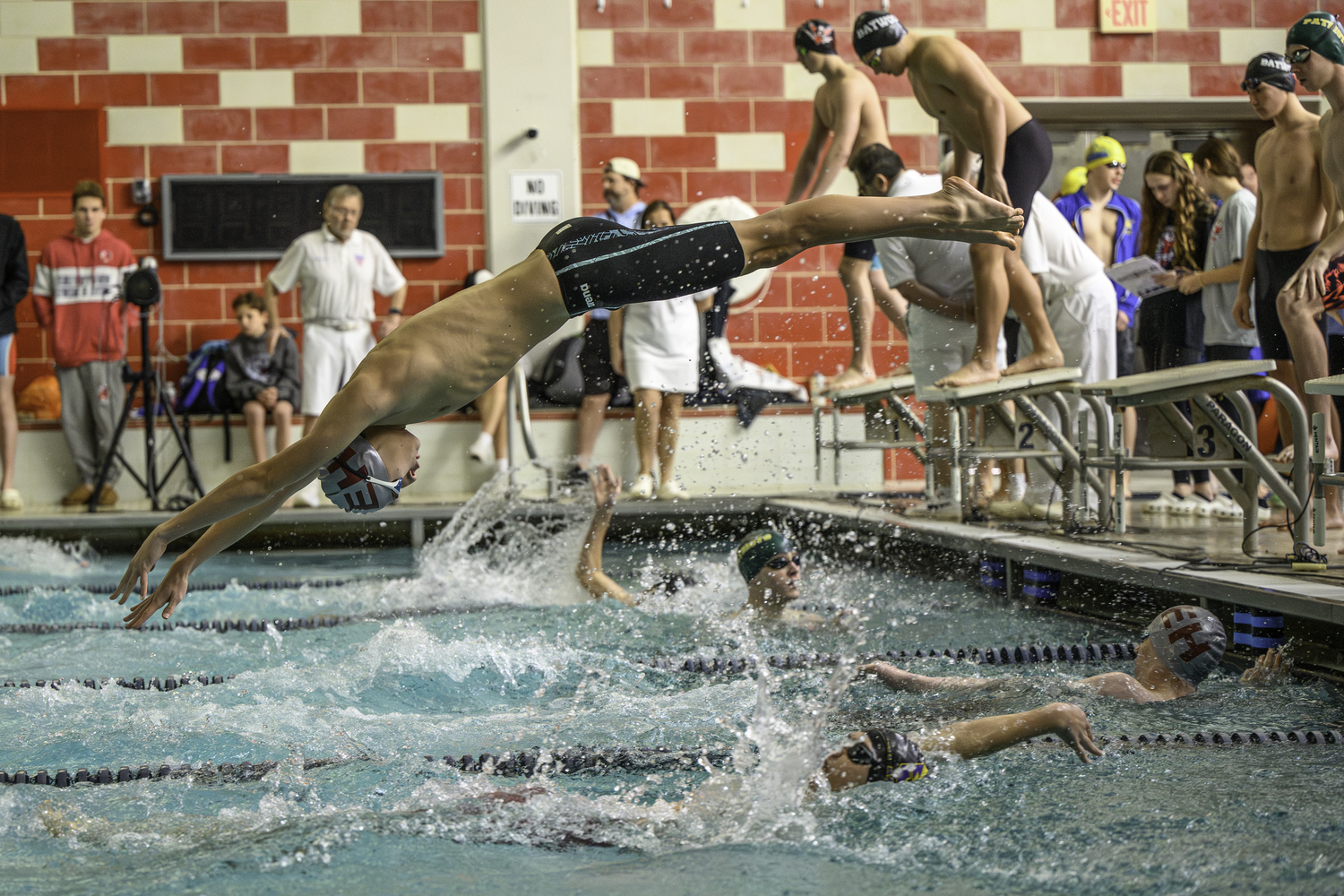 Nick Chavez dives into the pool for the start of the second leg of the 200-yard medley relay.   MARIANNE BARNETT