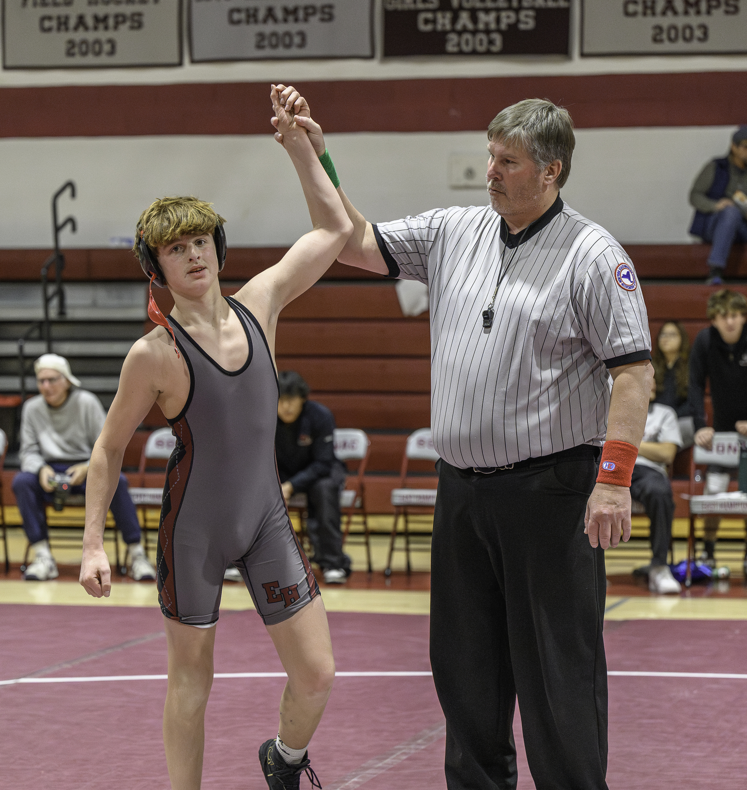 East Hampton's Caleb Mott gets his arm raised after a victory.  MARIANNE BARNETT