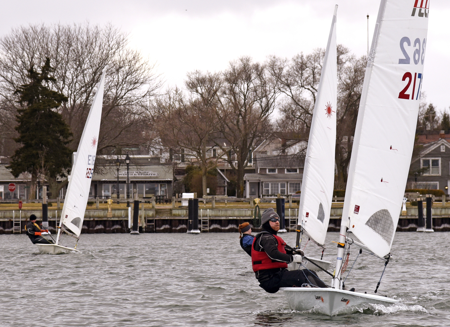 First place Peter Beardsley approaching the finish line ahead of third place Rudy Ratsep on the left and fourth place Venetia Satow a few boat lengths behind Peter.   MICHAEL MELLA