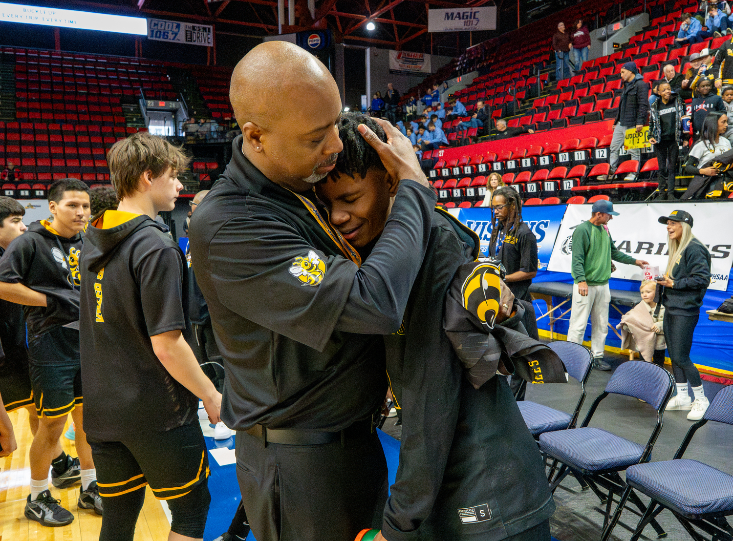 Eddie Dawson hugs his son who goes by the same name after his 11 points were crucial for the Bees in their state semifinal win.  RON ESPOSITO