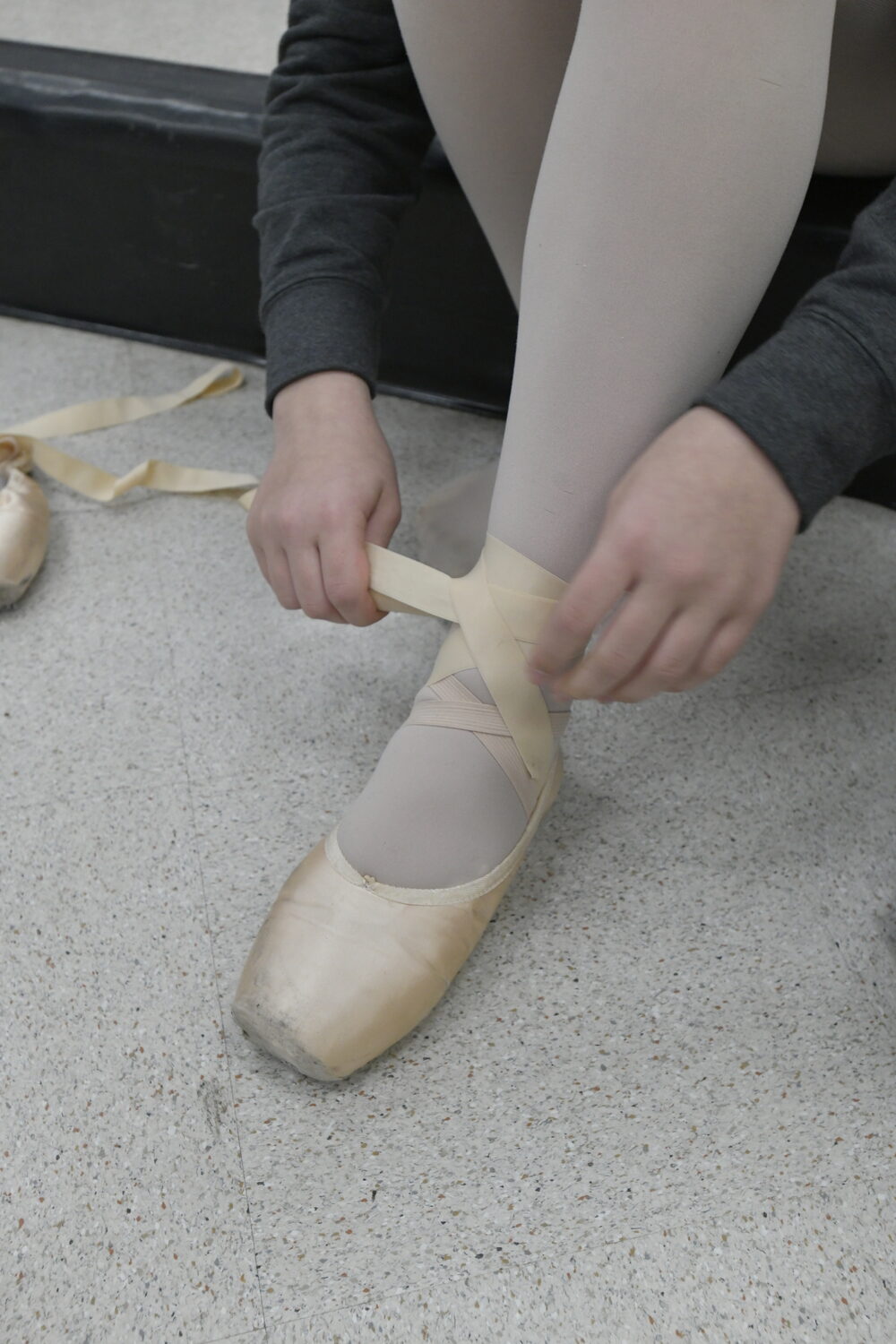 Lacing up the pointe shoes.