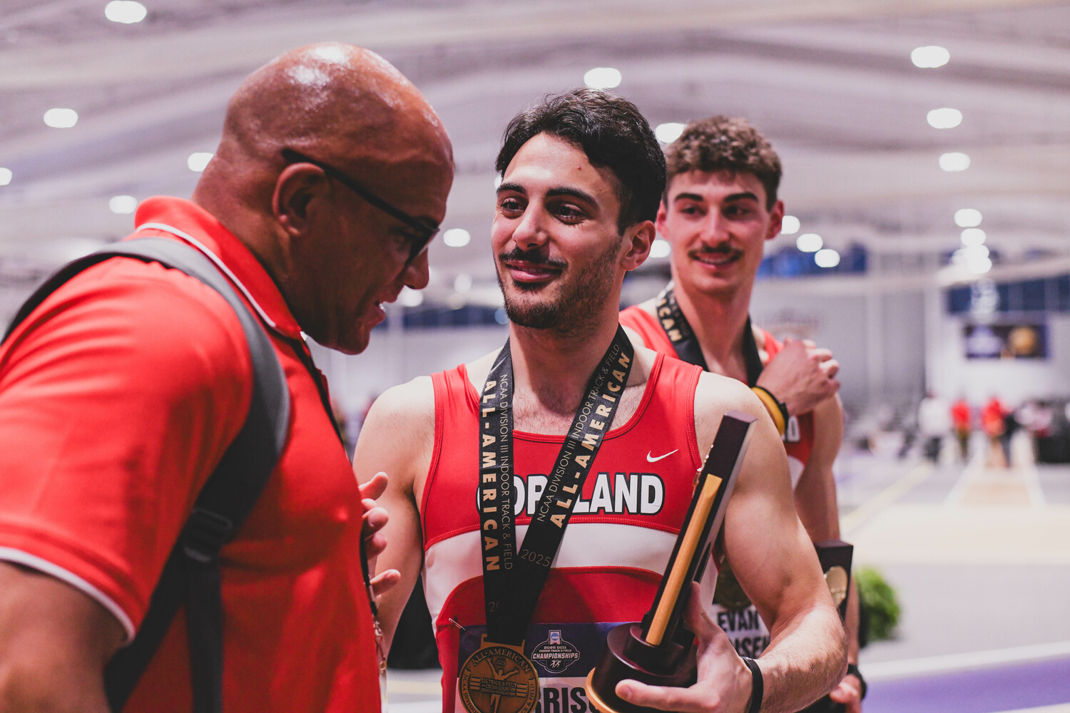 Harrison Gavalas shows off his new national championship trophy to coach Curtis Merrick.  EDL PHOTOGRAPHY/ERIN LOCASCIO